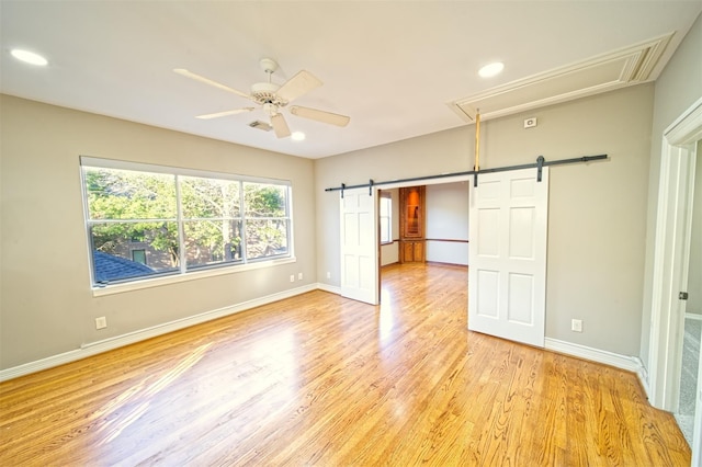 910 Peachwood Bend Dr, Houston, TX 77077 - unfurnished bedroom featuring attic access, light wood-type flooring, baseboards, recessed lighting, and a barn door