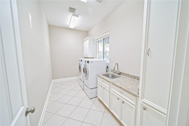 910 Peachwood Bend Dr, Houston, TX 77077 - laundry room with cabinet space, washing machine and dryer, light tile patterned floors, and baseboards
