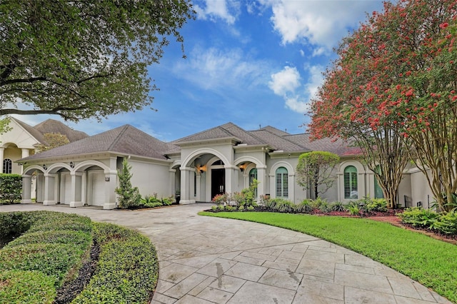 910 Peachwood Bend Dr, Houston, TX 77077 - mediterranean / spanish-style home with stucco siding, curved driveway, a front yard, and roof with shingles