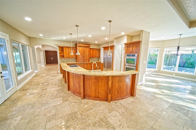 910 Peachwood Bend Dr, Houston, TX 77077 - kitchen featuring a sink, stone tile floors, arched walkways, recessed lighting, and baseboards