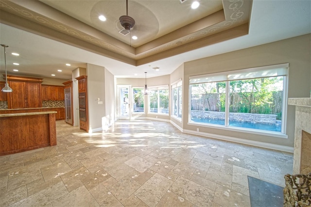 910 Peachwood Bend Dr, Houston, TX 77077 - unfurnished living room with baseboards, stone tile flooring, a raised ceiling, recessed lighting, and ceiling fan