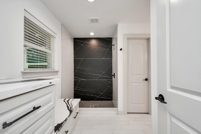 1805 E Ave, Katy, TX 77493 - full bathroom with vanity, a marble finish shower, marble look tiles, and recessed lighting