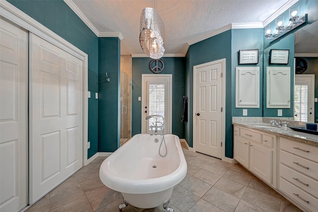 bathroom featuring plenty of natural light, a freestanding bath, ornamental molding, tile patterned floors, and vanity