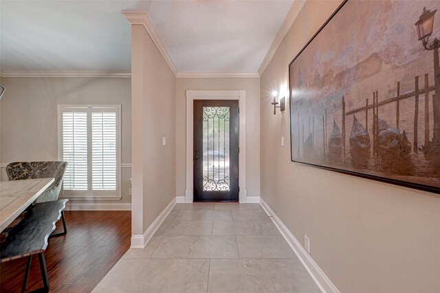 foyer with crown molding, plenty of natural light, and baseboards