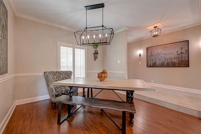 dining area featuring a chandelier, wood finished floors, crown molding, and baseboards