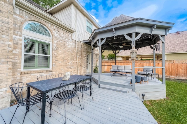 wooden deck featuring an outdoor living space, fence, ceiling fan, and outdoor dining area