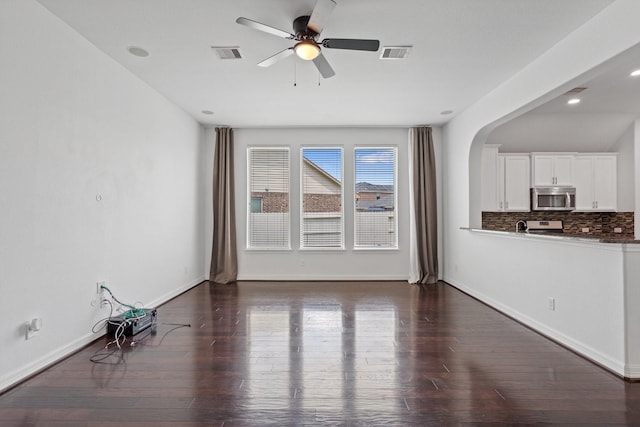 326 Lake Rim Dr, Rosenberg, TX 77469 - unfurnished living room featuring a ceiling fan, dark wood-style flooring, arched walkways, baseboards, and recessed lighting