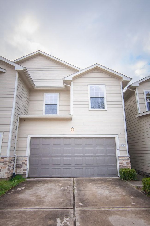 11317 Elegant Way, Houston, TX 77066 - view of front facade featuring an attached garage, stone siding, and driveway