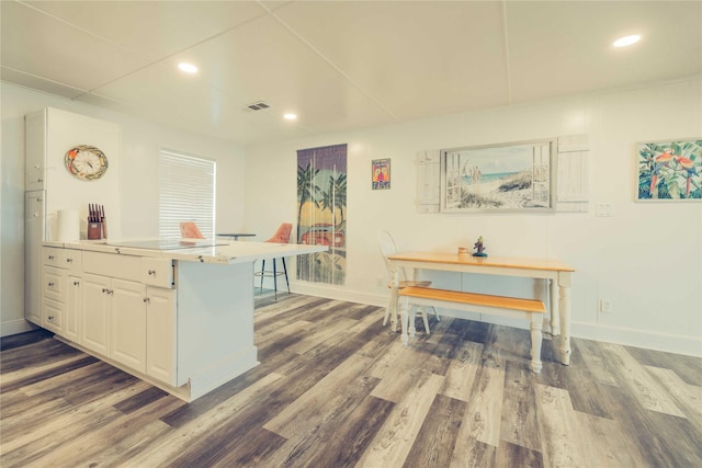 kitchen featuring wood finished floors, baseboards, black electric cooktop, white cabinetry, and recessed lighting