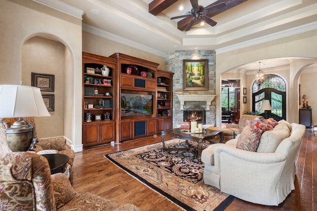 38 Post Shadow Estate Dr, Spring, TX 77389 - living area featuring arched walkways, ceiling fan, a stone fireplace, a raised ceiling, and wood finished floors
