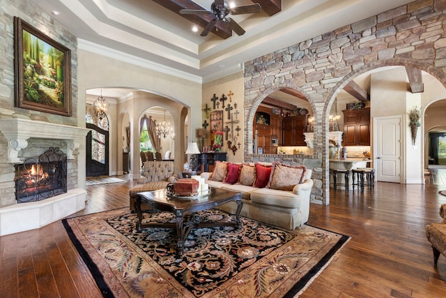 38 Post Shadow Estate Dr, Spring, TX 77389 - living room with arched walkways, ceiling fan, dark wood-type flooring, a warm lit fireplace, and a high ceiling