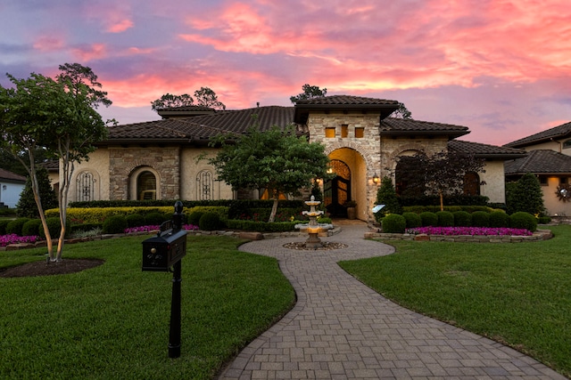 38 Post Shadow Estate Dr, Spring, TX 77389 - mediterranean / spanish house featuring stone siding, a tiled roof, a lawn, and stucco siding
