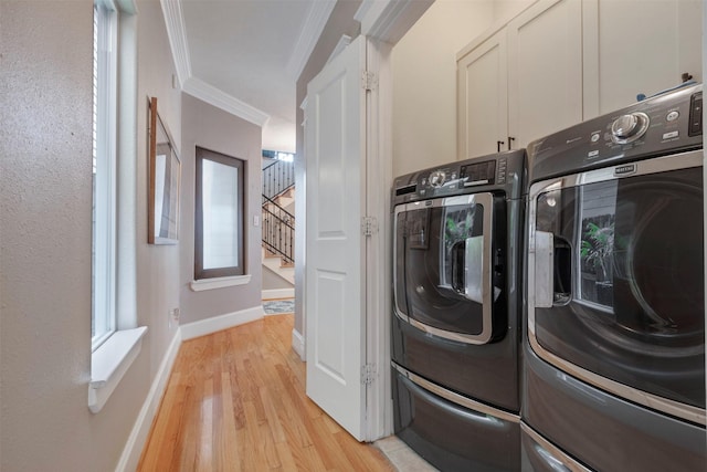 1309 Nashua St Unit A, Houston, TX 77008 - laundry area with ornamental molding, light wood-style floors, washer and dryer, baseboards, and cabinet space