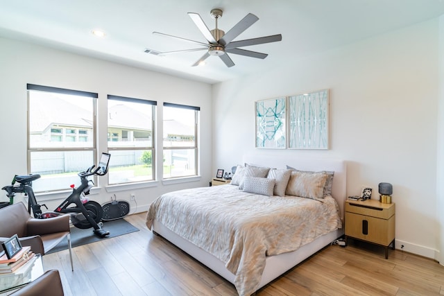 bedroom featuring light wood-style floors, baseboards, and a ceiling fan