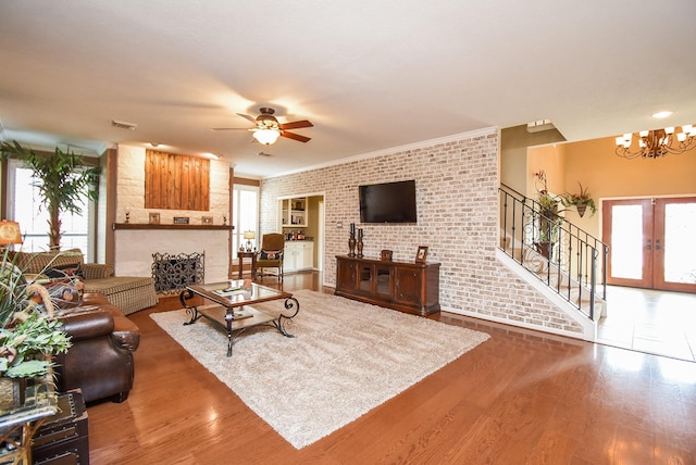 14 Wickham Ct, Sugar Land, TX 77479 - living area with brick wall, a chandelier, stairs, wood finished floors, and ceiling fan