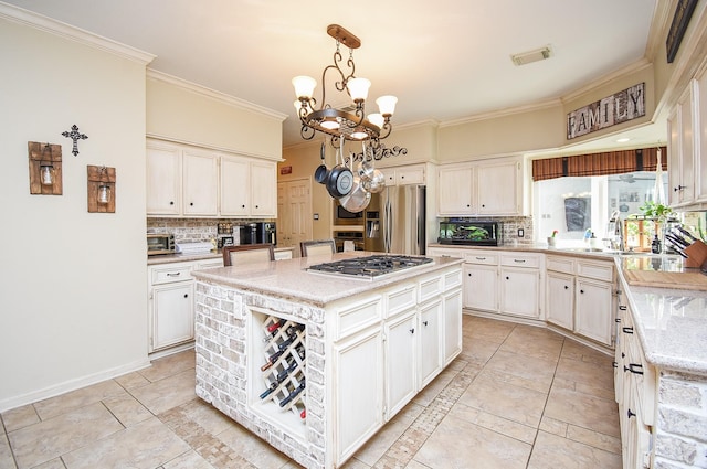 14 Wickham Ct, Sugar Land, TX 77479 - kitchen featuring appliances with stainless steel finishes, a sink, backsplash, ornamental molding, and a chandelier