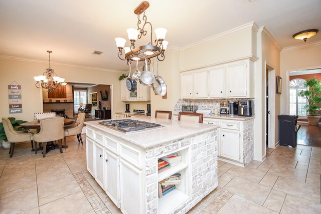 14 Wickham Ct, Sugar Land, TX 77479 - kitchen featuring a chandelier, stainless steel gas stovetop, white cabinetry, healthy amount of natural light, and crown molding