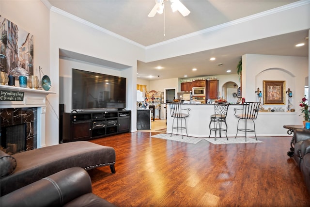 4635 Countrymeadows Dr, Spring, TX 77388 - living area featuring ceiling fan, dark wood-type flooring, crown molding, a premium fireplace, and arched walkways