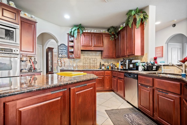 4635 Countrymeadows Dr, Spring, TX 77388 - kitchen featuring stainless steel appliances, arched walkways, a sink, tasteful backsplash, and recessed lighting