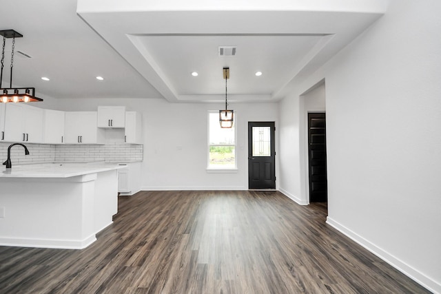 1029 Gazing Pine St, Huffman, TX 77336 - kitchen with dark wood-type flooring, light countertops, white cabinetry, baseboards, and backsplash
