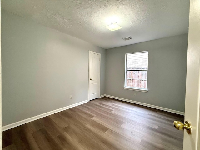 5223 Mountain Forest Dr, Katy, TX 77449 - spare room with dark wood-style floors, baseboards, and a textured ceiling