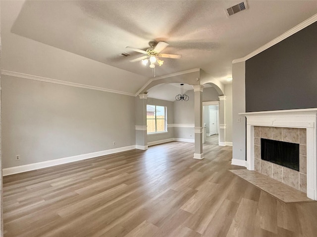 5223 Mountain Forest Dr, Katy, TX 77449 - unfurnished living room with arched walkways, ceiling fan, a fireplace, baseboards, and a textured ceiling