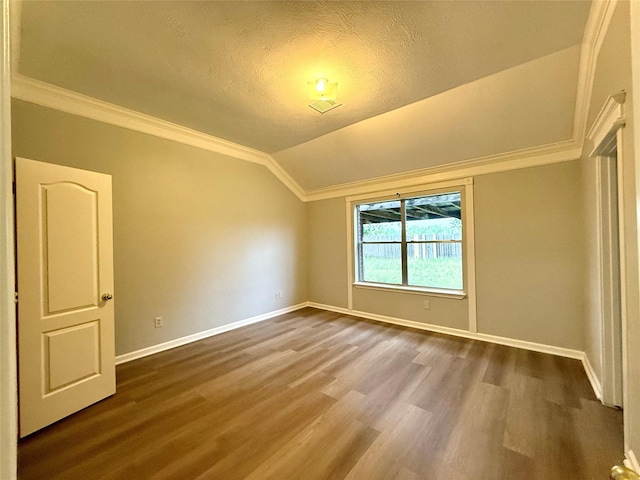 5223 Mountain Forest Dr, Katy, TX 77449 - unfurnished room featuring ornamental molding, baseboards, dark wood-type flooring, vaulted ceiling, and a textured ceiling