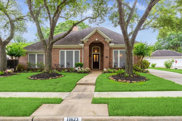 traditional-style home with brick siding, a front lawn, roof with shingles, and a chimney