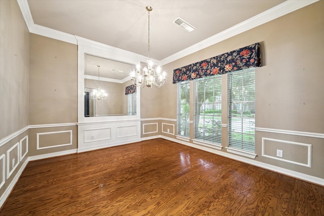 unfurnished dining area with a chandelier, a decorative wall, crown molding, wood finished floors, and a wainscoted wall