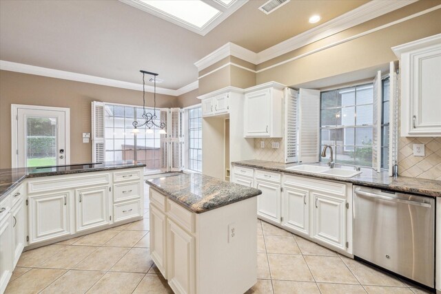 kitchen featuring dishwasher, a sink, ornamental molding, light tile patterned flooring, and dark stone countertops