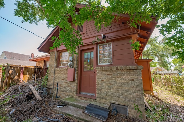 rear view of house with fence and brick siding