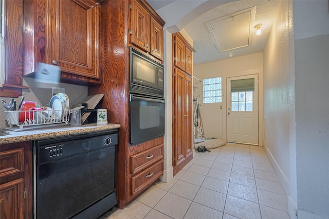kitchen featuring black appliances, light tile patterned floors, baseboards, and brown cabinetry