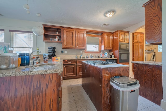 kitchen featuring black appliances, a sink, open shelves, backsplash, and plenty of natural light