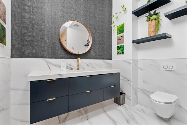 1 Waterway Ct Unit 4B, The Woodlands, TX 77380 - bathroom featuring marble tiled flooring, tile walls, vanity, toilet, and a wainscoted wall