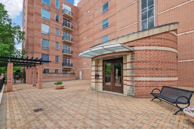 1 Waterway Ct Unit 4B, The Woodlands, TX 77380 - property entrance featuring french doors, a pergola, and brick siding