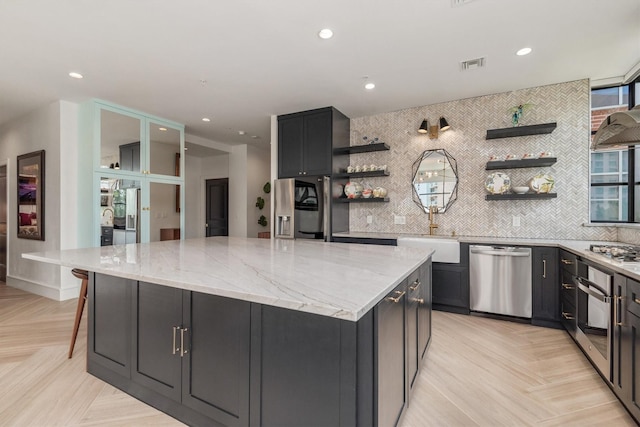 1 Waterway Ct Unit 4B, The Woodlands, TX 77380 - kitchen featuring stainless steel appliances, open shelves, a sink, a large island, and light stone countertops