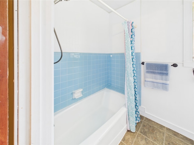 full bath with baseboards and shower / bathtub combination with curtain