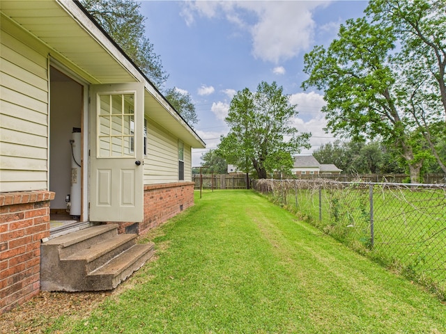 view of yard featuring water heater and entry steps