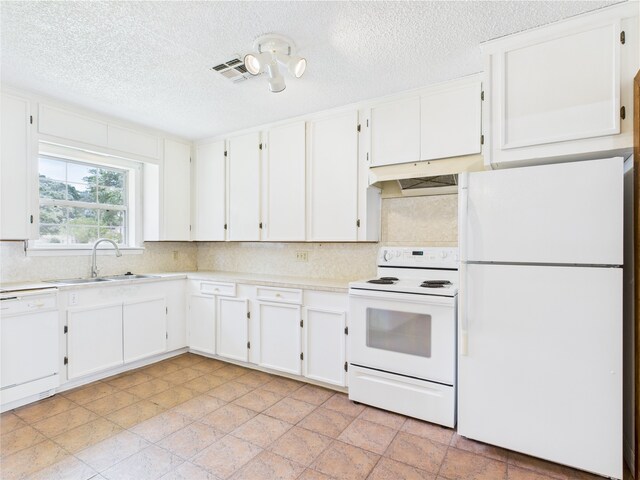 kitchen with white appliances, a sink, light countertops, decorative backsplash, and a textured ceiling