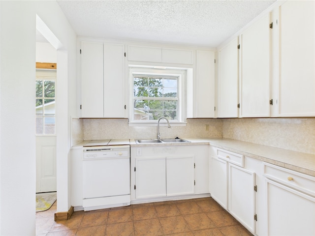 kitchen with white dishwasher, a sink, plenty of natural light, tasteful backsplash, and a textured ceiling