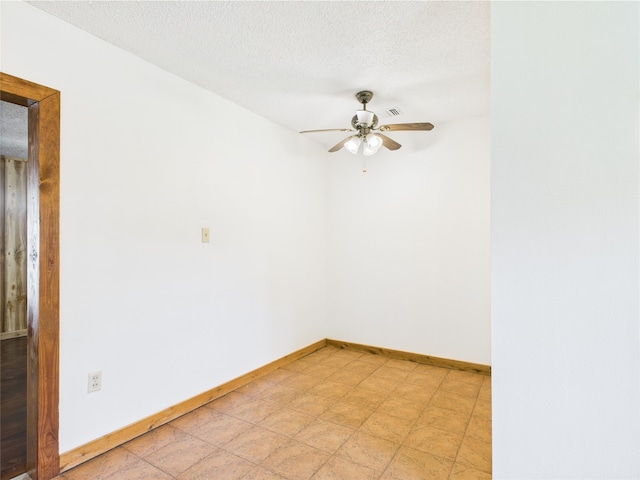 spare room with ceiling fan, baseboards, and a textured ceiling
