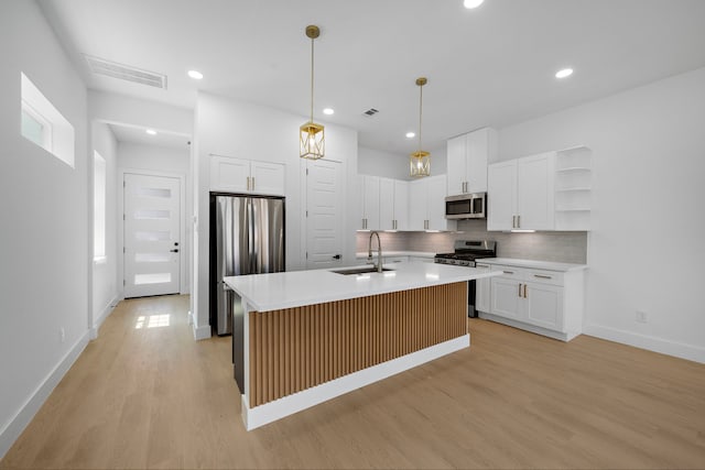 1307 Amundsen St N, Houston, TX 77009 - kitchen featuring appliances with stainless steel finishes, a sink, light wood finished floors, open shelves, and tasteful backsplash