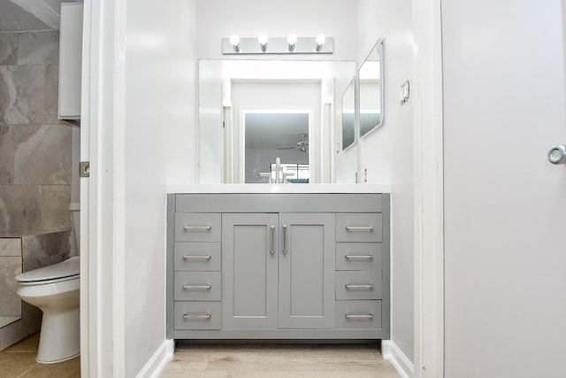 6633 W Airport Unit 1103, Houston, TX 77035 - bathroom featuring toilet, vanity, baseboards, and wood finished floors