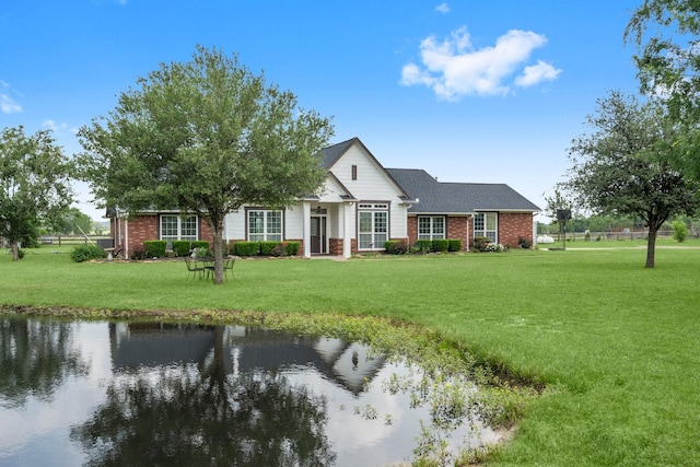 34334 Howell Rd, Waller, TX 77484 - view of front of property with brick siding, a front yard, and a water view