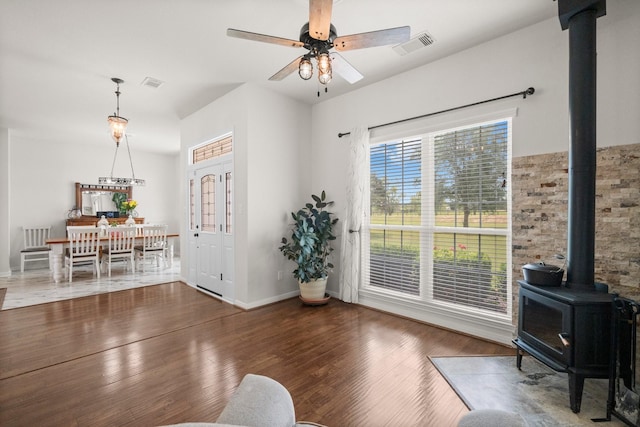 34334 Howell Rd, Waller, TX 77484 - living room featuring a wood stove, wood finished floors, ceiling fan, and baseboards