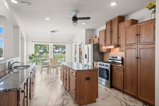 34334 Howell Rd, Waller, TX 77484 - kitchen with stainless steel appliances, a sink, a center island, under cabinet range hood, and light marble finish floors