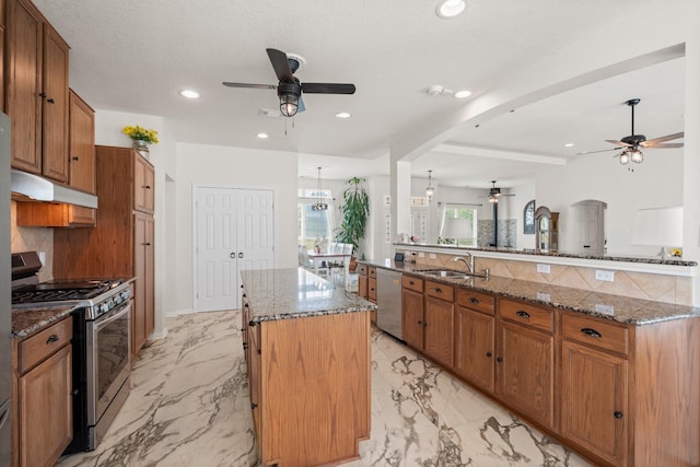 34334 Howell Rd, Waller, TX 77484 - kitchen featuring ceiling fan, appliances with stainless steel finishes, under cabinet range hood, a kitchen island, and recessed lighting