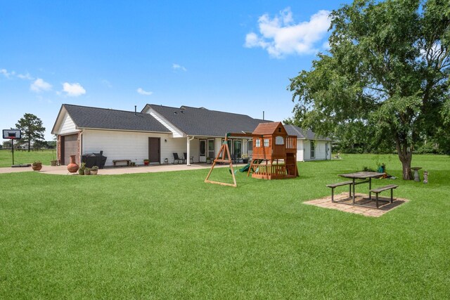 34334 Howell Rd, Waller, TX 77484 - rear view of property featuring a yard, a playground, an attached garage, a patio area, and concrete driveway