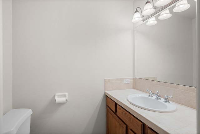 34334 Howell Rd, Waller, TX 77484 - half bathroom featuring tasteful backsplash, vanity, toilet, and a chandelier