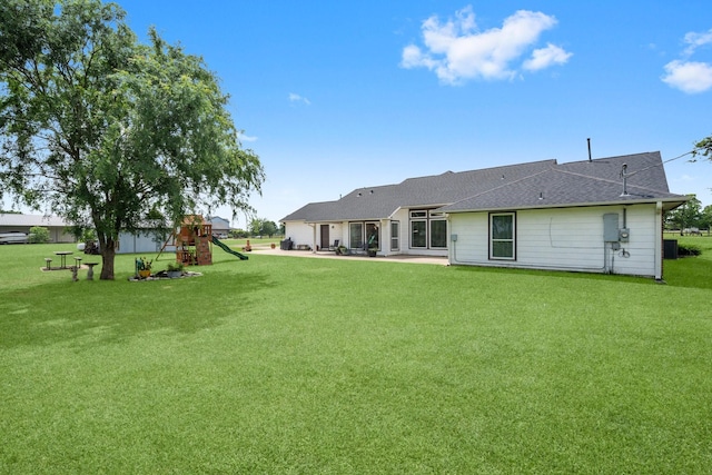 34334 Howell Rd, Waller, TX 77484 - rear view of house with a playground, a lawn, a patio area, and a shingled roof